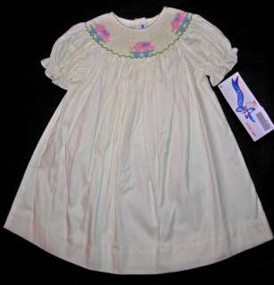 This cute yellow smocked bishop dress is accented with pink elephant 